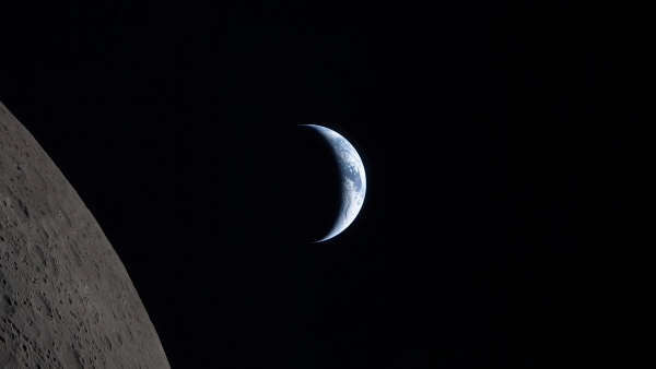 A crescent Earth in the background of a black field of space with a bit of the Moon in the foreground
